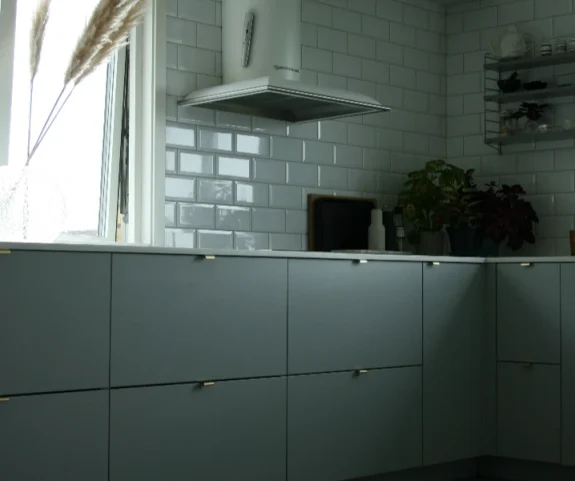Ett kök i skandinavisk design med fokus på naturliga material, här med en stilren vit klinkers som ger ett modernt och fräscht intryck. Göteborg.