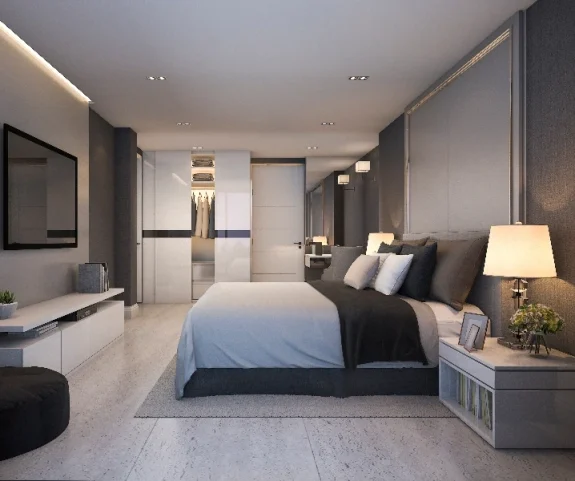 Ett minimalistiskt hotellsovrum med enkla linjer och dämpade färger i beige och svart. En säng med högkvalitativa sängkläder och mjuka kuddar är placerad i ena sidan av rummet. Hotellinredning Göteborg.