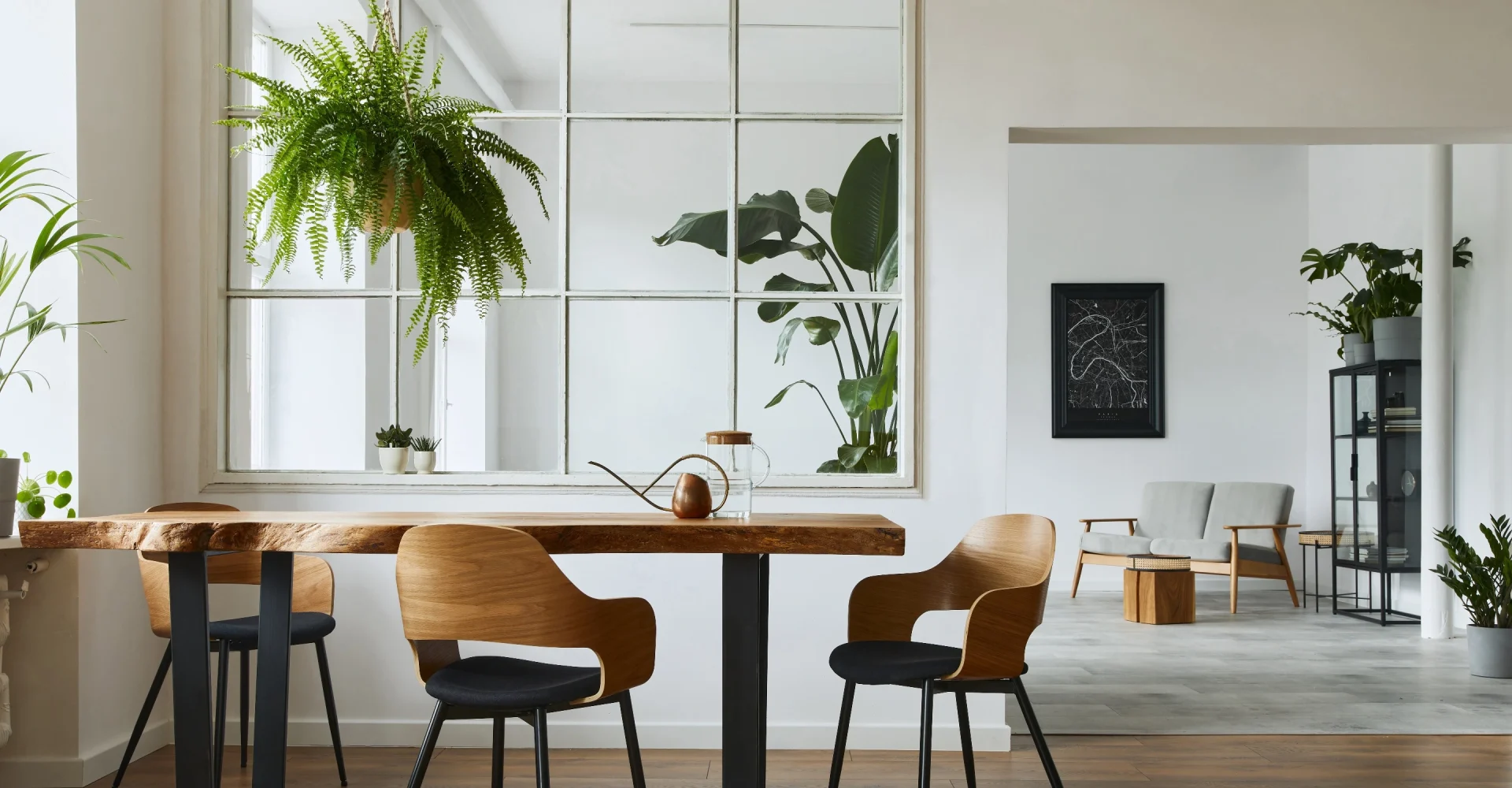 Ett modernt kontorslandskap med vita väggar, gröna växter och designade trämöbler på ett ljust trägolv. Kontorsinredning i Göteborg av högsta kvalité.