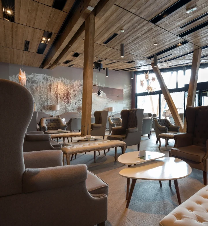 En varm och inbjudande stugrestaurang med högt i tak och öppen planlösning. Interiören präglas av trä och exklusiva bruna läder fåtöljer, vilket ger en rustik och bekväm atmosfär. Göteborg.