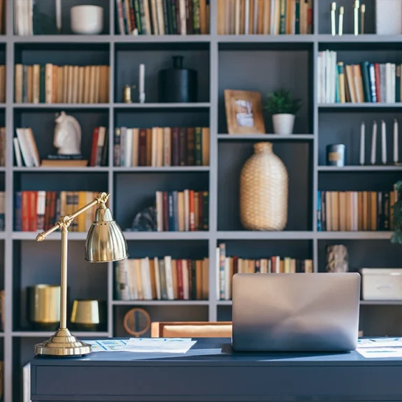 Stilrent och vackert kontor med imponerande bokhylla i bakgrunden, rena linjer och ljusa färger som ger en inspirerande arbetsmiljö. Göteborg.